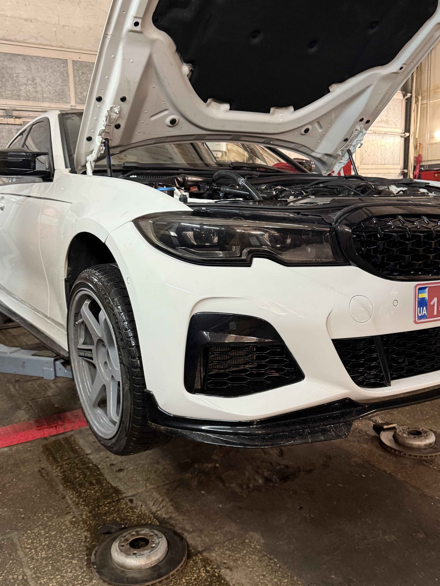 Біла BMW G20 з відкритим капотом