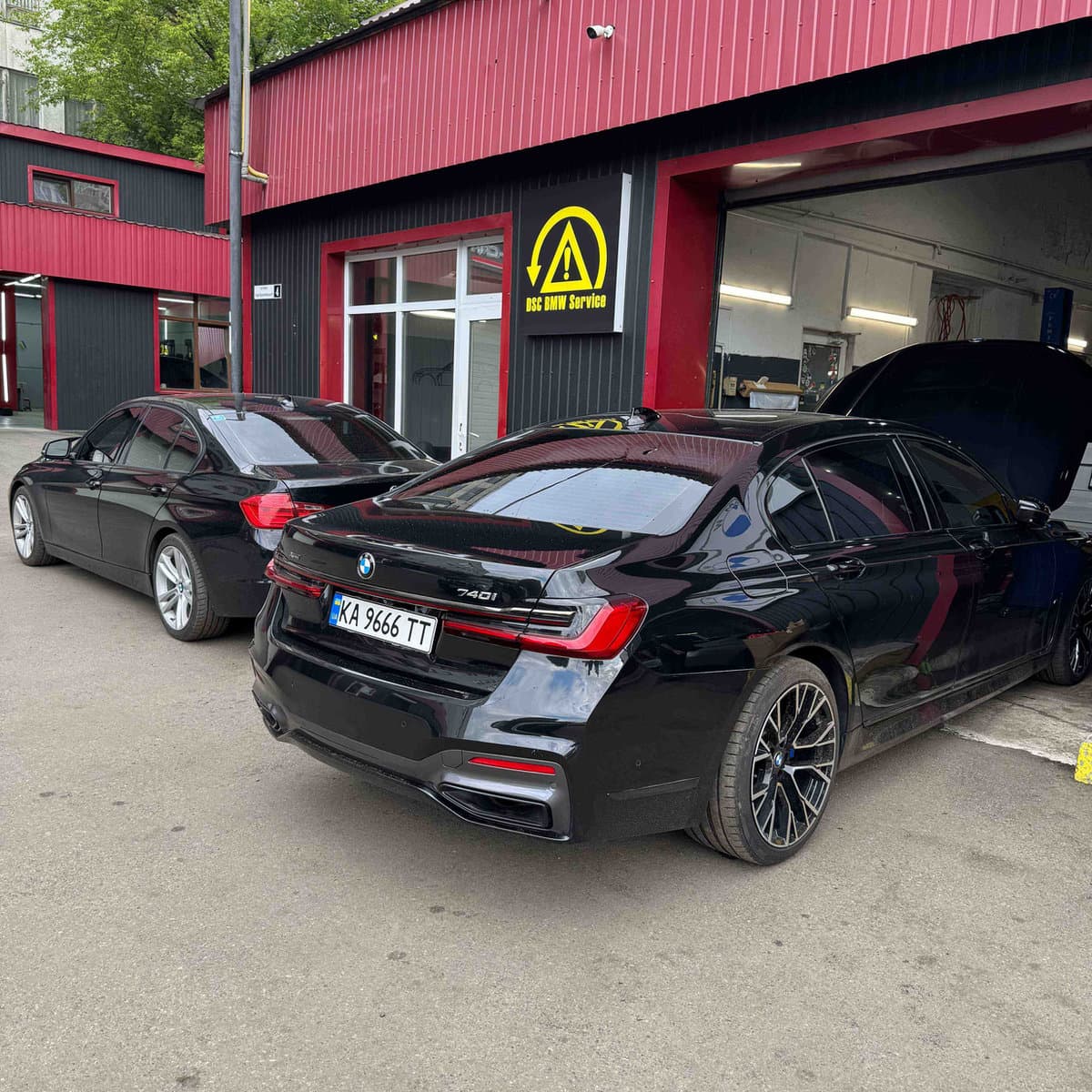 Темні BMW 7-series біля станції