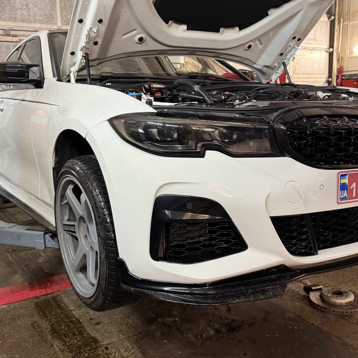 Біла BMW G20 з відкритим капотом